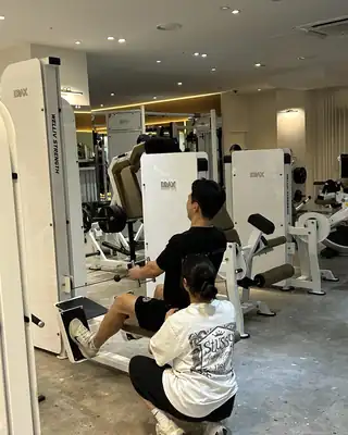 로우 머신에서 회원의 등 자세를 코칭하는 모습