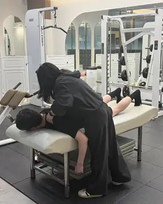 엎드린 회원의 허리 주변 긴장을 풀어 주는 모습
